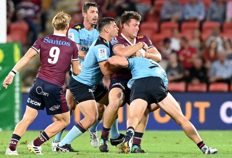 Harry Hoopert of the Reds is tackled during the round one Super Rugby AU match between the Queensland Reds and the New South Wales Waratahs at Suncorp Stadium, on February 19, 2021, in Brisbane, Australia. (Photo by Bradley Kanaris/Getty Images)