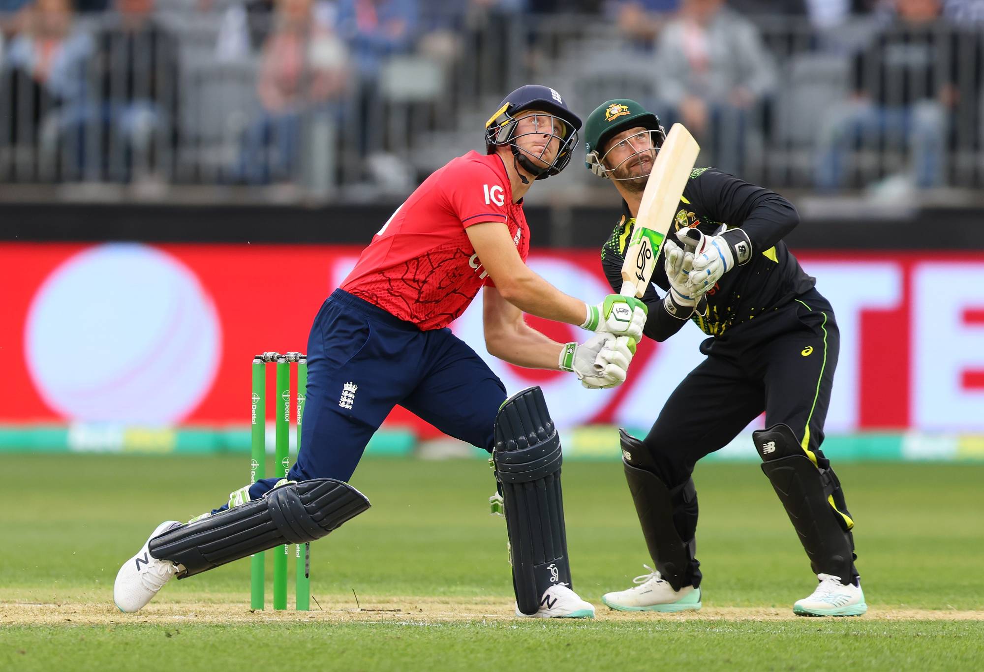 PERTH, AUSTRALIA - OCTOBER 09: Jos Buttler of England and Matthew Wade of Australia watch the ball go for six during game one of the T20 International series between Australia and England at Optus Stadium on October 09, 2022 in Perth, Australia. (Photo by James Worsfold/Getty Images)