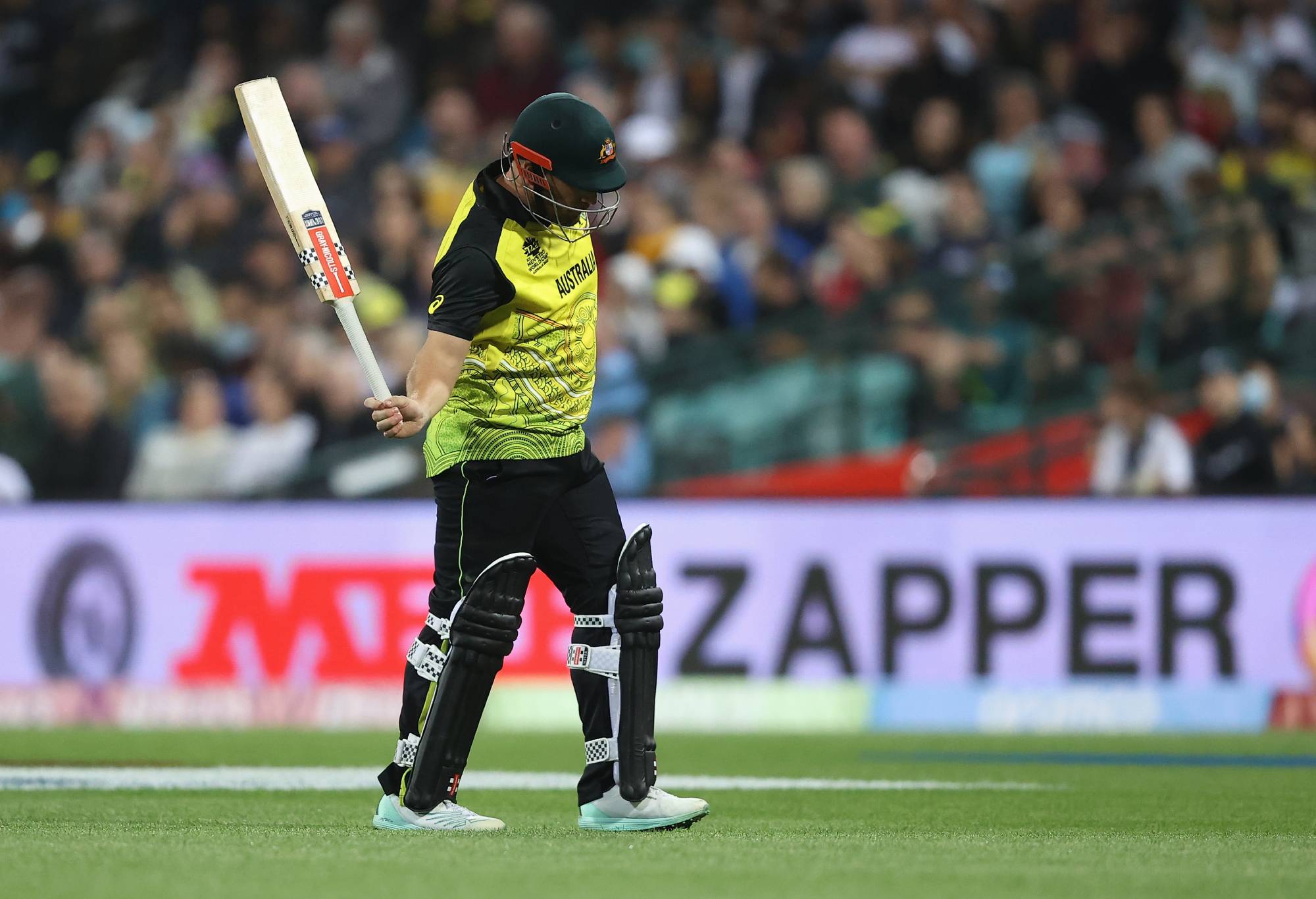 SYDNEY, AUSTRALIA - OCTOBER 22: Aaron Finch of Australia leaves the pitch after being dismissed by Mitchell Santner of New Zealand during the ICC Men's T20 World Cup match between Australia and New Zealand at Sydney Cricket Ground on October 22, 2022 in Sydney, Australia.  (Photo by Mark Kolbe/Getty Images)