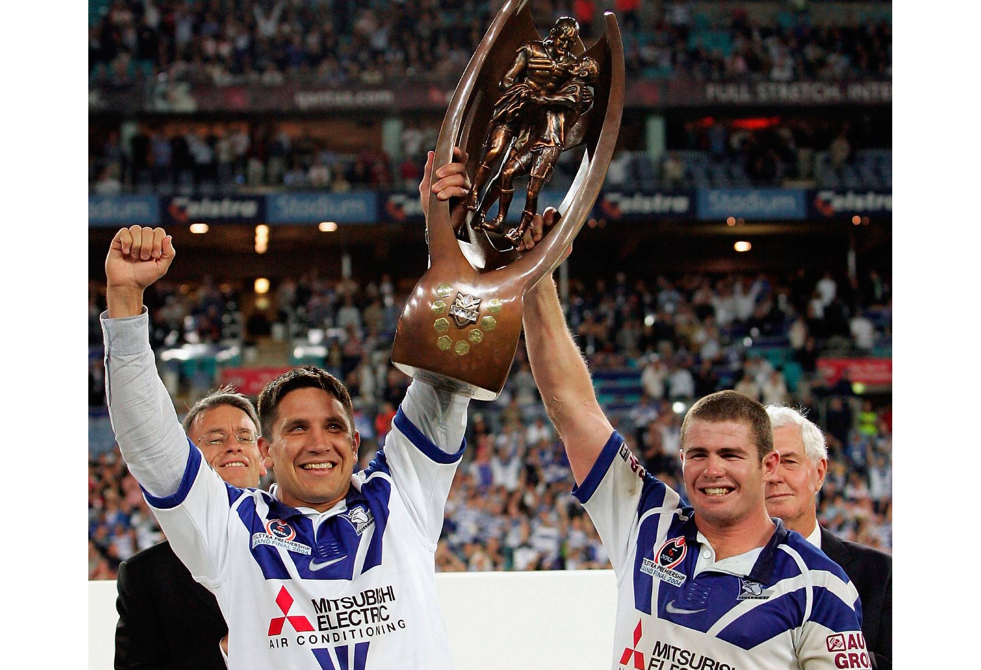 SYDNEY, AUSTRALIA - OCTOBER 3: (L-R) Injured captain Steve Price and stand in captain Andrew Ryan of the Bulldogs celebrate with the trophy during the NRL Grand Final  between the Sydney Roosters and the Bulldogs held at Telstra Stadium, October 3, 2004 in Sydney, Australia. (Photo by Nick Laham/Getty Images)
