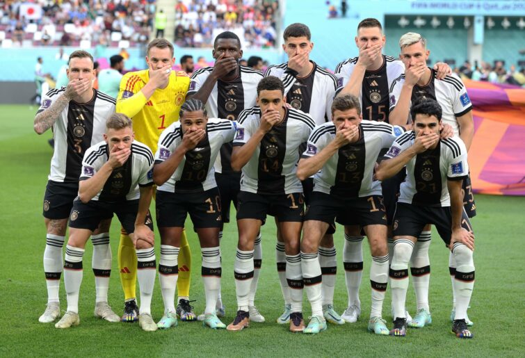 Germany players pose with their hands covering their mouths as they line up for the team photos prior to the FIFA World Cup Qatar 2022 Group E match between Germany and Japan at Khalifa International Stadium on November 23, 2022 in Doha, Qatar. (Photo by Alexander Hassenstein/Getty Images