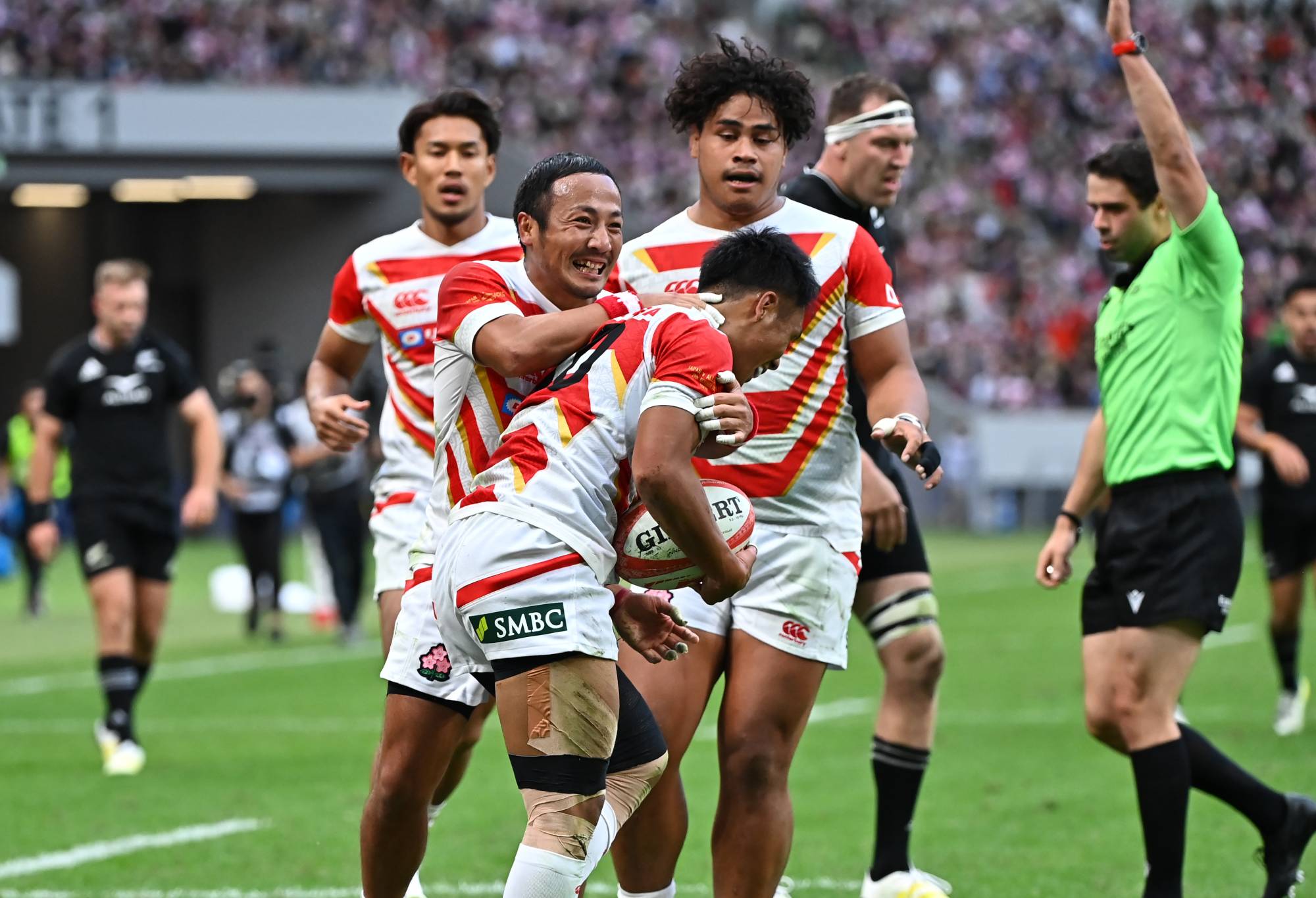 Takuya Yamasawa (C)of Japan is congratulated by his teammates after scoring his side's first try during the international test match between Japan and New Zealand All Blacks at National Stadium on October 29, 2022 in Tokyo, Japan. (Photo by Kenta Harada/Getty Images)