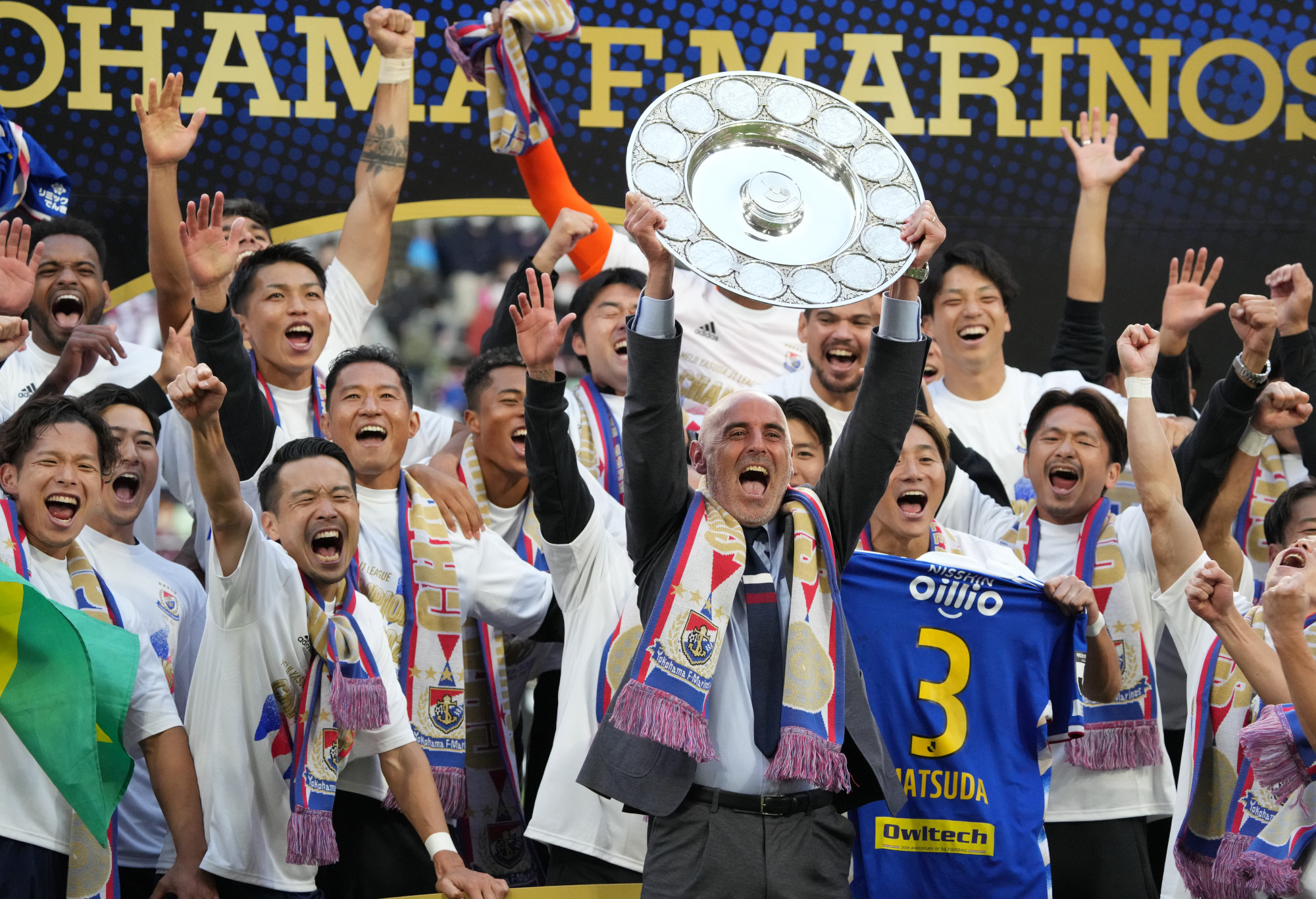 Yokohama F.Marinos celebrate victory as manager Kevin Mascut lifts the trophy.