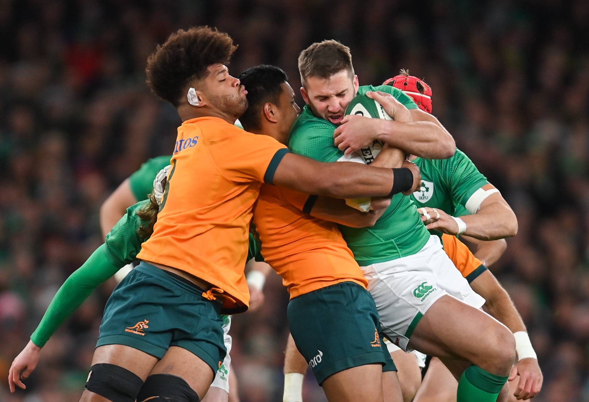 Stuart McCloskey of Ireland is tackled by Rob Valentini, left, and Len Ikitau of Australia during the Bank of Ireland Nations Series match between Ireland and Australia at the Aviva Stadium in Dublin. (Photo By Ramsey Cardy/Sportsfile via Getty Images)