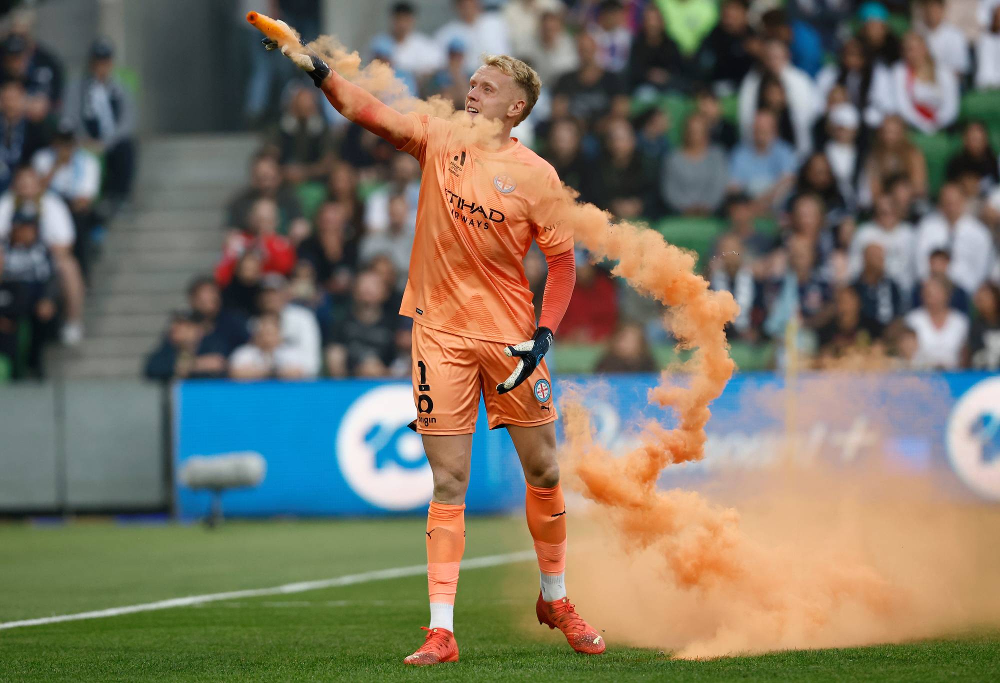 MELBOURNE, AUSTRALIA - DECEMBER 17: Tom Glover of Melbourne City picks up a flare to remove it from the pitch during the round eight A-League Men's match between Melbourne City and Melbourne Victory at AAMI Park, on December 17, 2022, in Melbourne, Australia. (Photo by Darrian Traynor/Getty Images)