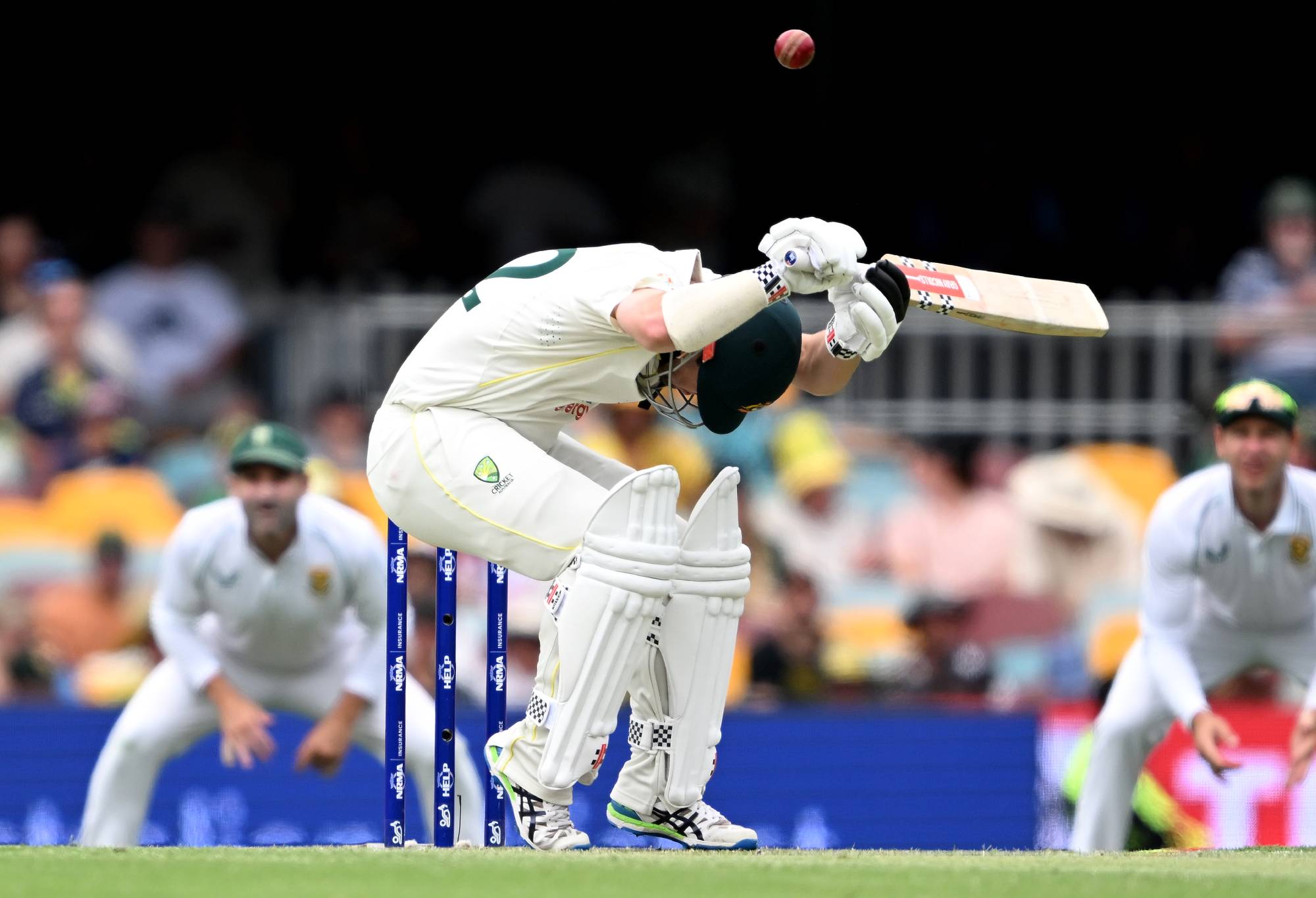 BRISBANE, AUSTRALIA - DECEMBER 18: Travis Head of Australia ducks under a bouncer during day two of the First Test match between Australia and South Africa at The Gabba on December 18, 2022 in Brisbane, Australia. (Photo by Bradley Kanaris/Getty Images)