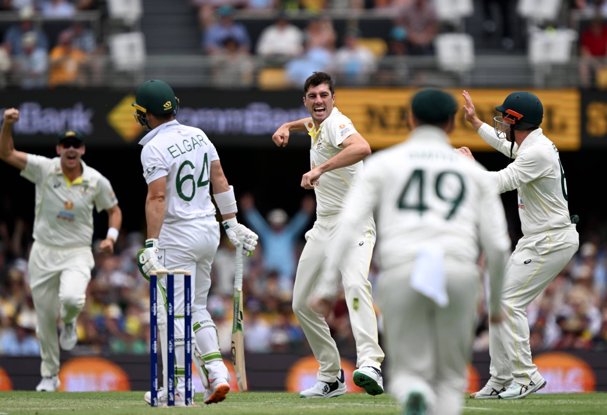 BRISBANE, AUSTRALIA - DECEMBER 18: Pat Cummins of Australia celebrates with team mates after taking the wicket of Dean Elgar of South Africa during day two of the First Test match between Australia and South Africa at The Gabba on December 18, 2022 in Brisbane, Australia. (Photo by Bradley Kanaris/Getty Images)