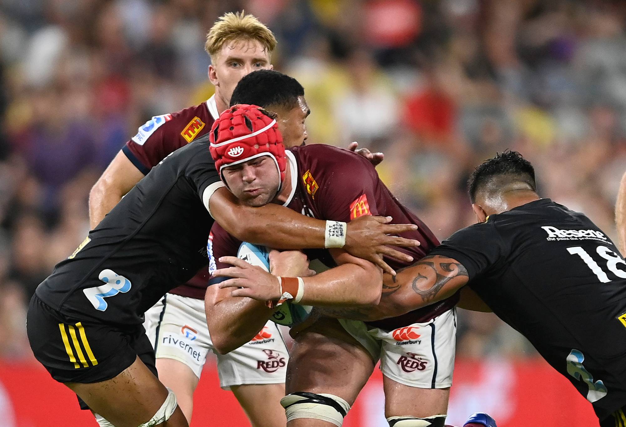 Harry Wilson of the Reds is tackled during the round one Super Rugby Pacific match between Queensland Reds and Hurricanes at Queensland Country Bank Stadium, on February 25, 2023, in Townsville, Australia. (Photo by Ian Hitchcock/Getty Images)