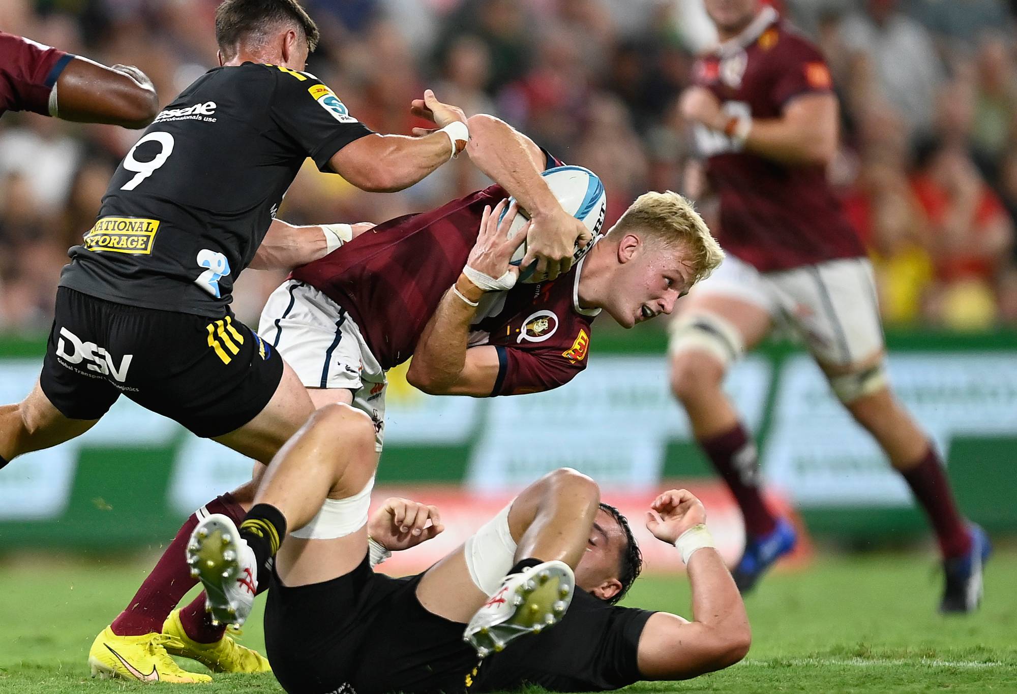TOWNSVILLE, AUSTRALIA - FEBRUARY 25: Tom Lynagh of the Reds is tackled during the round one Super Rugby Pacific match between Queensland Reds and Hurricanes at Queensland Country Bank Stadium, on February 25, 2023, in Townsville, Australia. (Photo by Ian Hitchcock/Getty Images)