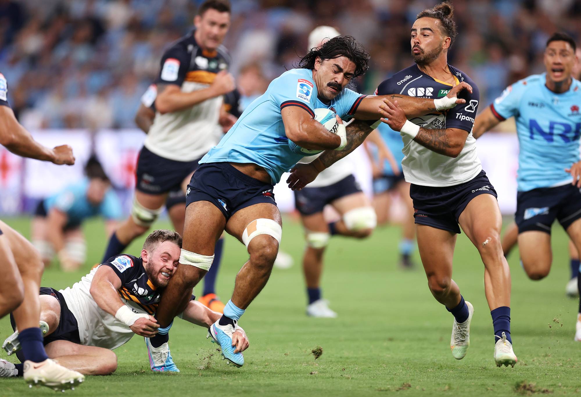 Charlie Gamble of the Waratahs is tackled