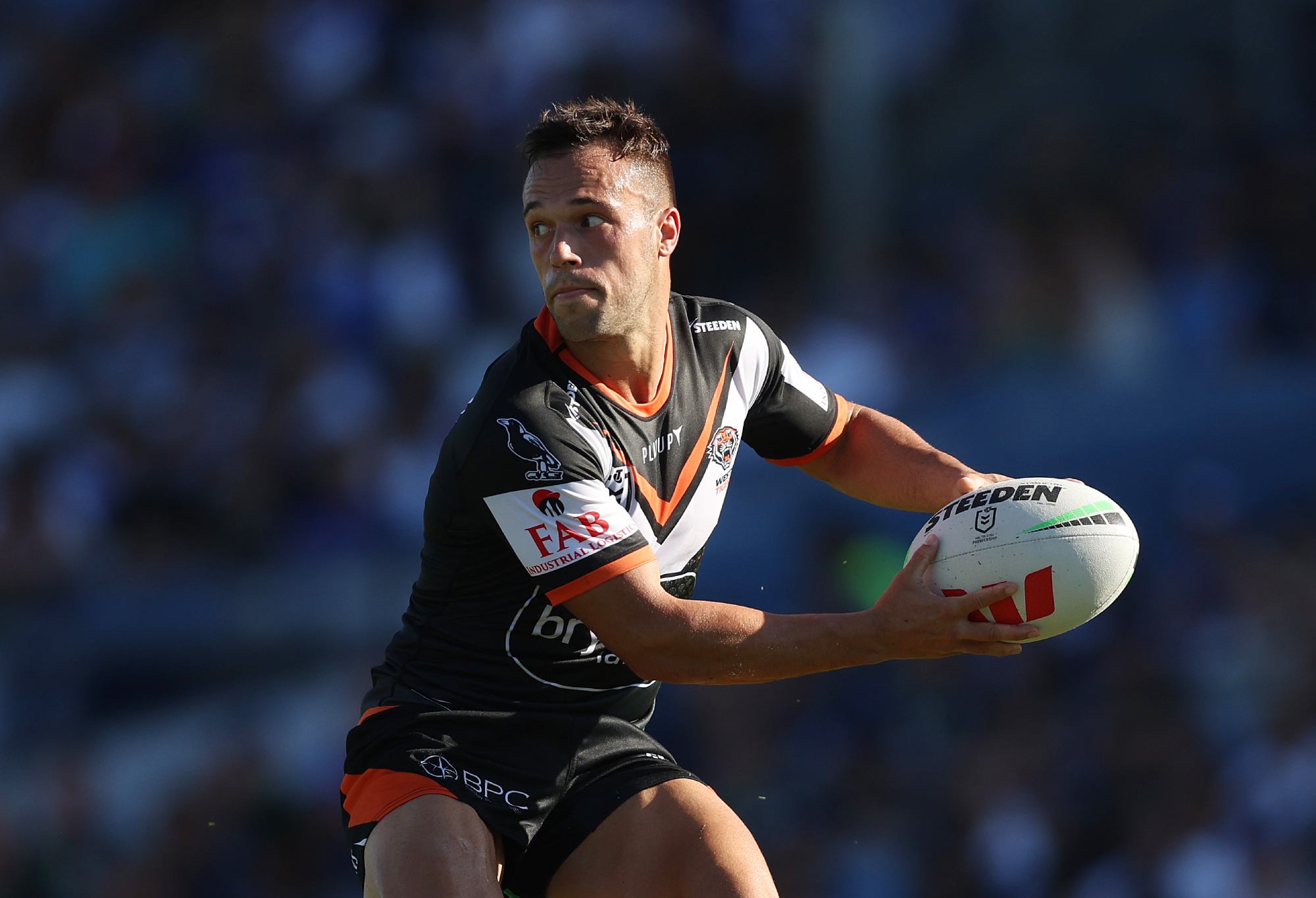 SYDNEY, AUSTRALIA - MARCH 19: Luke Brooks of the Wests Tigers looks to pass during the round three NRL match between Canterbury Bulldogs and Wests Tigers at Belmore Sports Ground on March 19, 2023 in Sydney, Australia. (Photo by Mark Metcalfe/Getty Images)