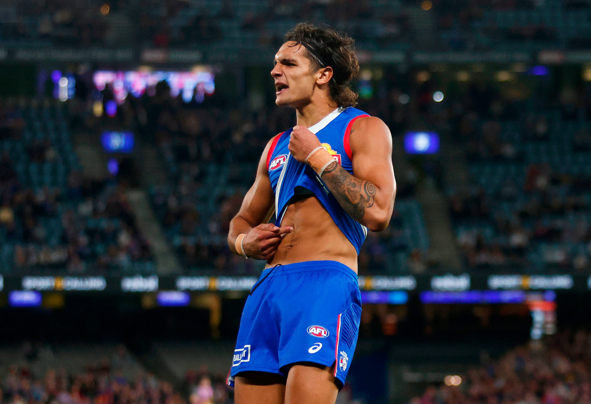 Jamarra Ugle-Hagan of the Western Bulldogs points to his skin as he celebrates kicking a goal.
