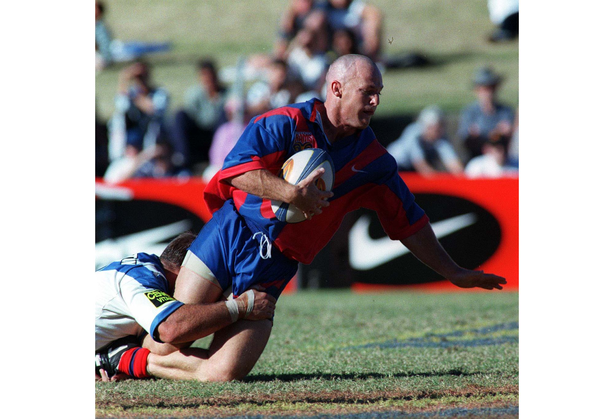 Former international Kerrod Walters is tackled while playing for the Adelaide Rams in 1997. (Photo: Getty Images)