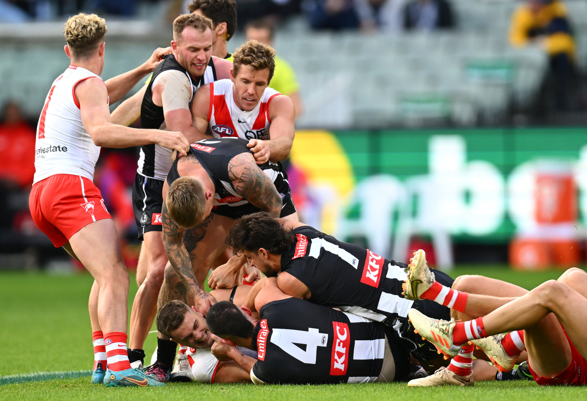 Collingwood and Sydney players wrestle.