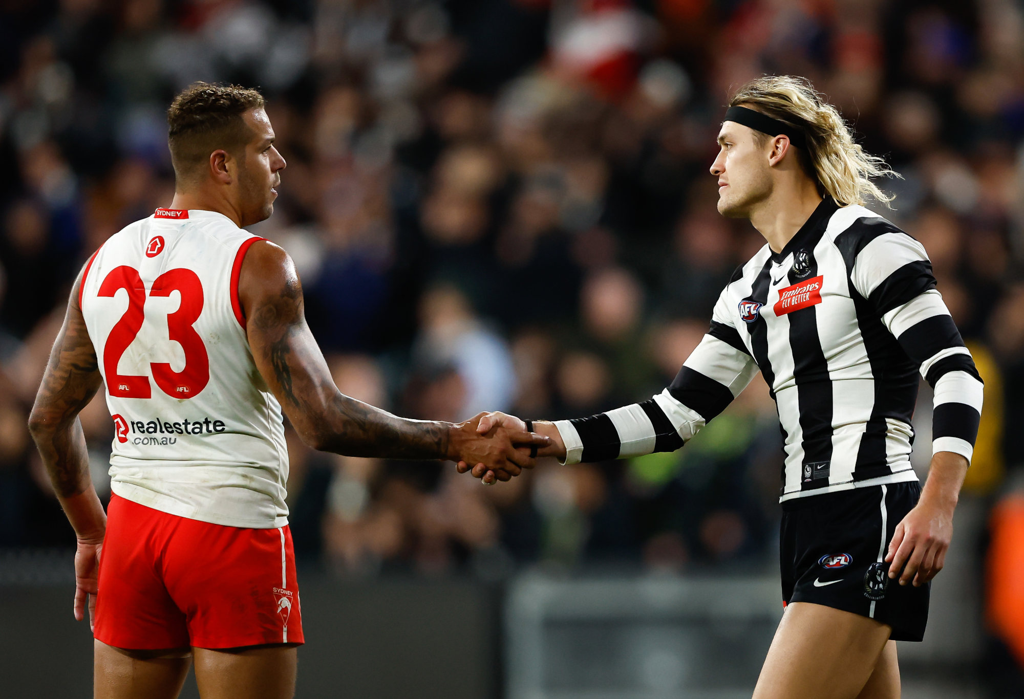Lance Franklin of the Swans and Darcy Moore of the Magpies shake hands.