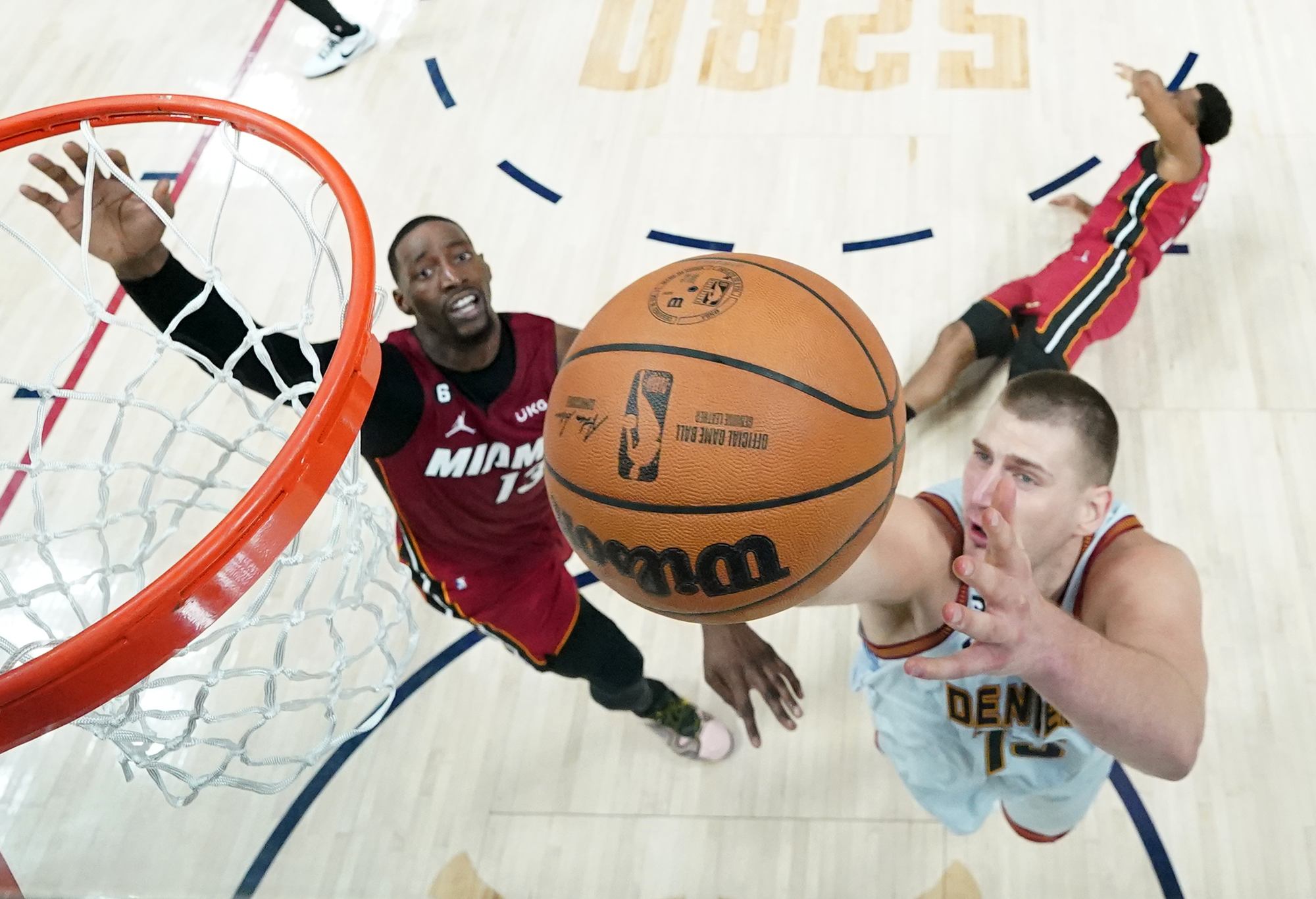 DENVER, COLORADO - JUNE 12: Nikola Jokic #15 of the Denver Nuggets drives to the basket against Bam Adebayo #13 of the Miami Heat during the first half in Game Five of the 2023 NBA Finals at Ball Arena on June 12, 2023 in Denver, Colorado. NOTE TO USER: User expressly acknowledges and agrees that, by downloading and or using this photograph, User is consenting to the terms and conditions of the Getty Images License Agreement. (Photo by Jack Dempsey - Pool/Getty Images)