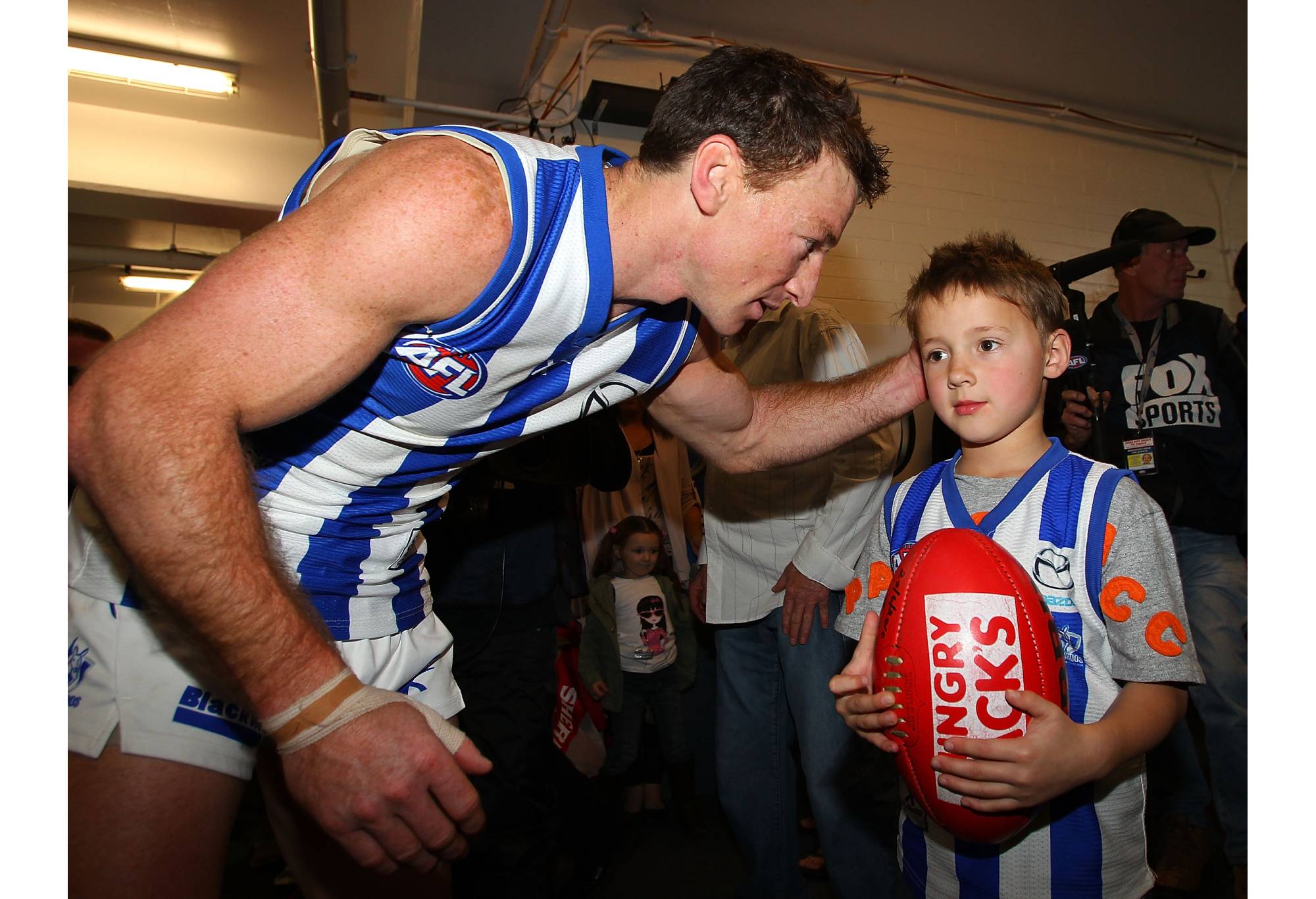 PERTH, AUSTRALIA - AUGUST 22: Brent Harvey of the Kangaroos hands the game ball to his son Cooper after playing his 300th game during the round 21 AFL match between the West Coast Eagles and the North Melbourne Kangaroos at Subiaco Oval on August 22, 2010 in Perth, Australia. (Photo by Paul Kane/Getty Images)