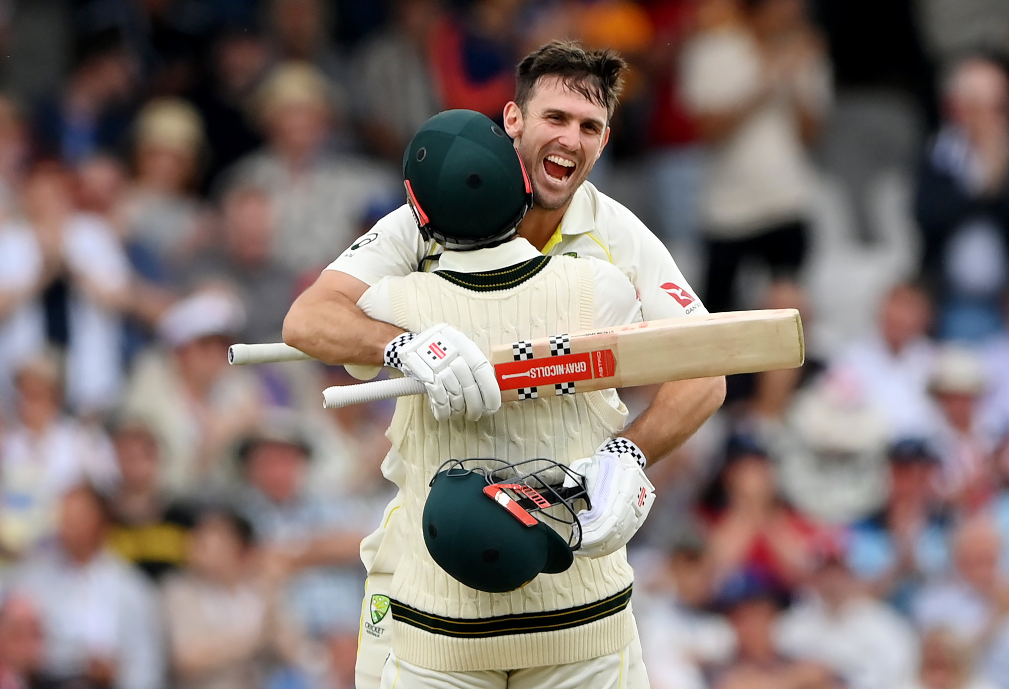 Mitchell Marsh celebrates with Travis Head after reaching his century.