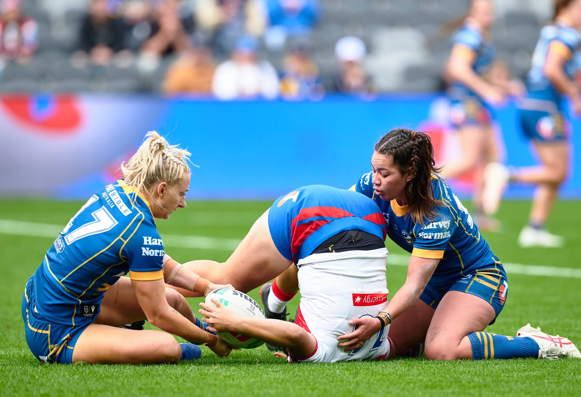 SYDNEY, AUSTRALIA - AUGUST 06: Laishon Albert-Jones of the Knights is tackled by Kennedy Cherrington of the Eels and Madeline Jones of the Eels during the round three NRLW match between Parramatta Eels and Newcastle Knights at CommBank Stadium, on August 06, 2023, in Sydney, Australia. (Photo by Brett Hemmings/Getty Images)