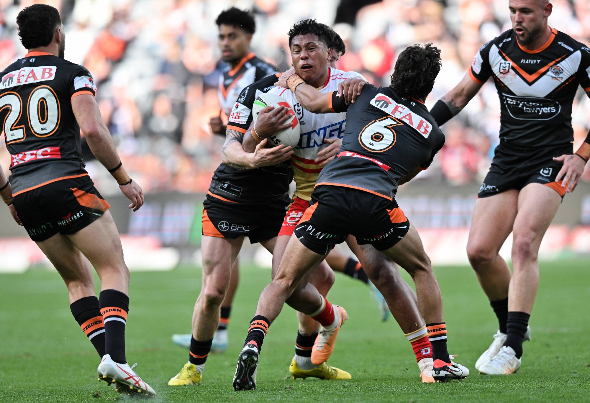 SYDNEY, AUSTRALIA - AUGUST 19: Tesi Niu of the Dolphins is tackled during the round 25 NRL match between Wests Tigers and Dolphins at CommBank Stadium on August 19, 2023 in Sydney, Australia. (Photo by Izhar Khan/Getty Images)