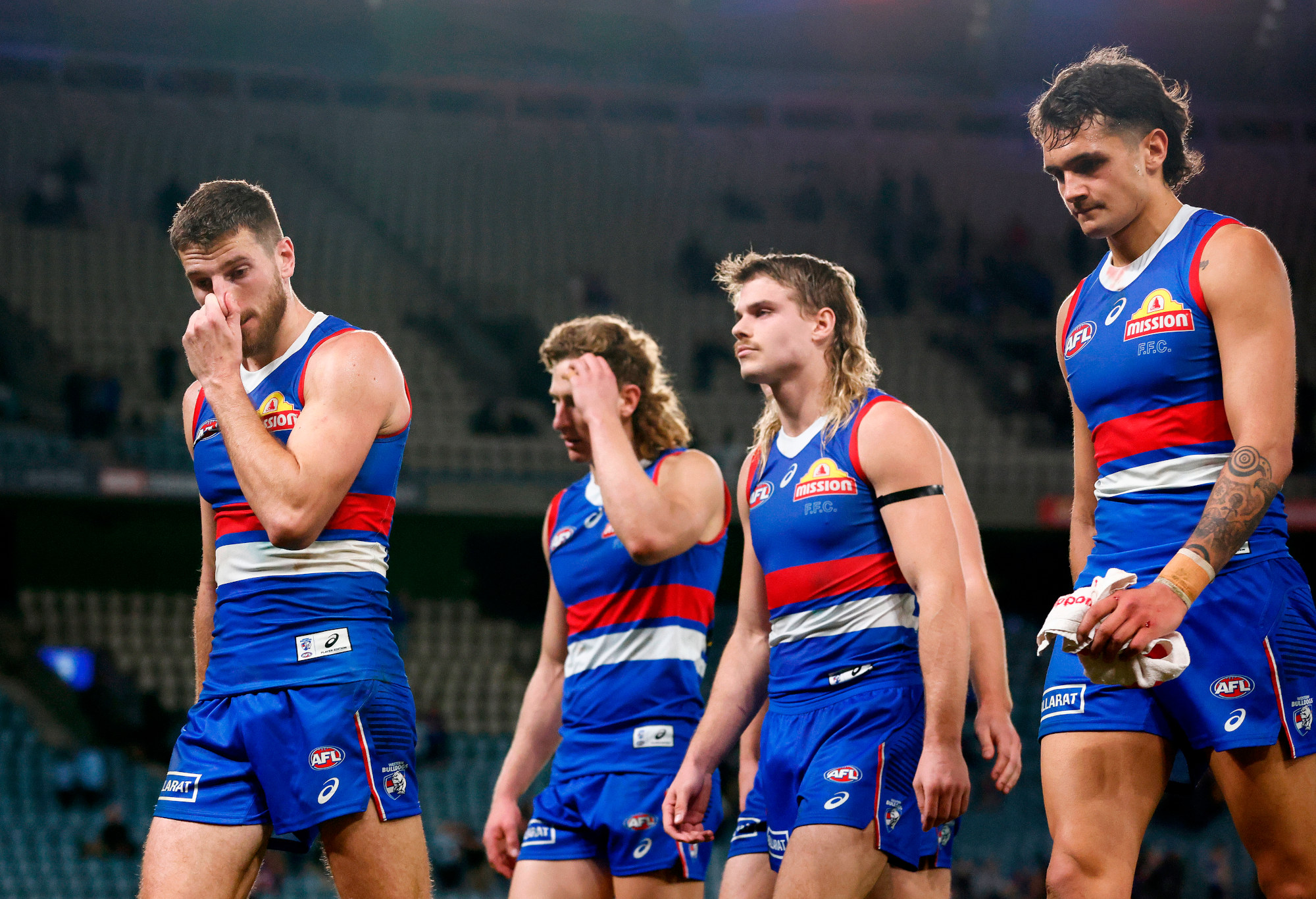 arcus Bontempelli and his Western Bulldogs teammates look dejected.