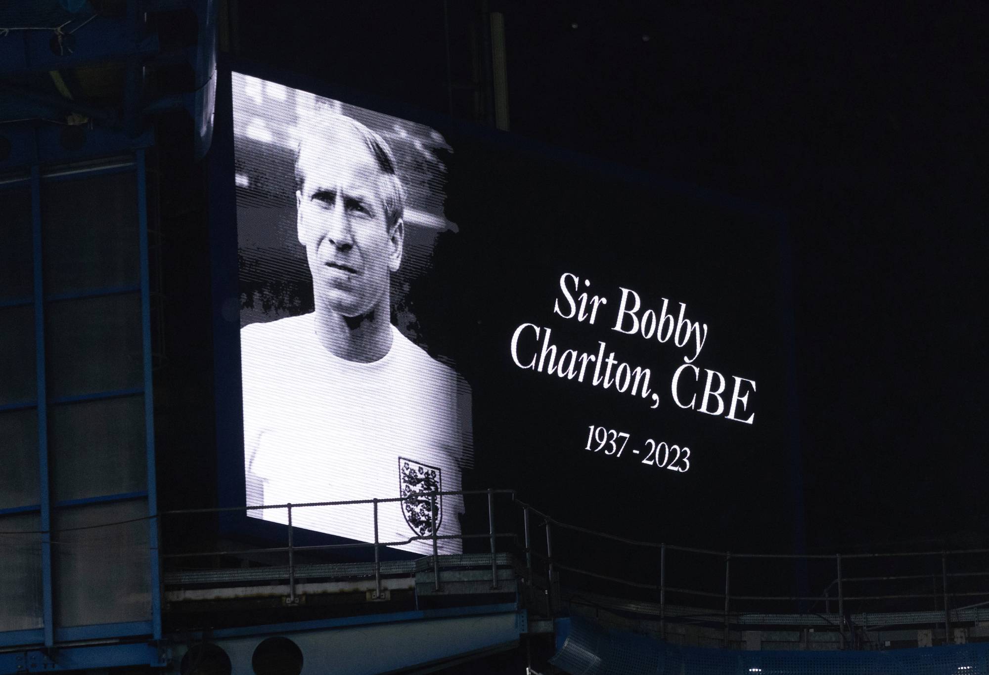 LONDON, ENGLAND - OCTOBER 21: A tribute to the late Sir Bobby Charlton is show on the big screen at half the trophy and celebrates time during the Premier League match between Chelsea FC and Arsenal FC at Stamford Bridge on October 21, 2023 in London, England. (Photo by Marc Atkins/Getty Images)