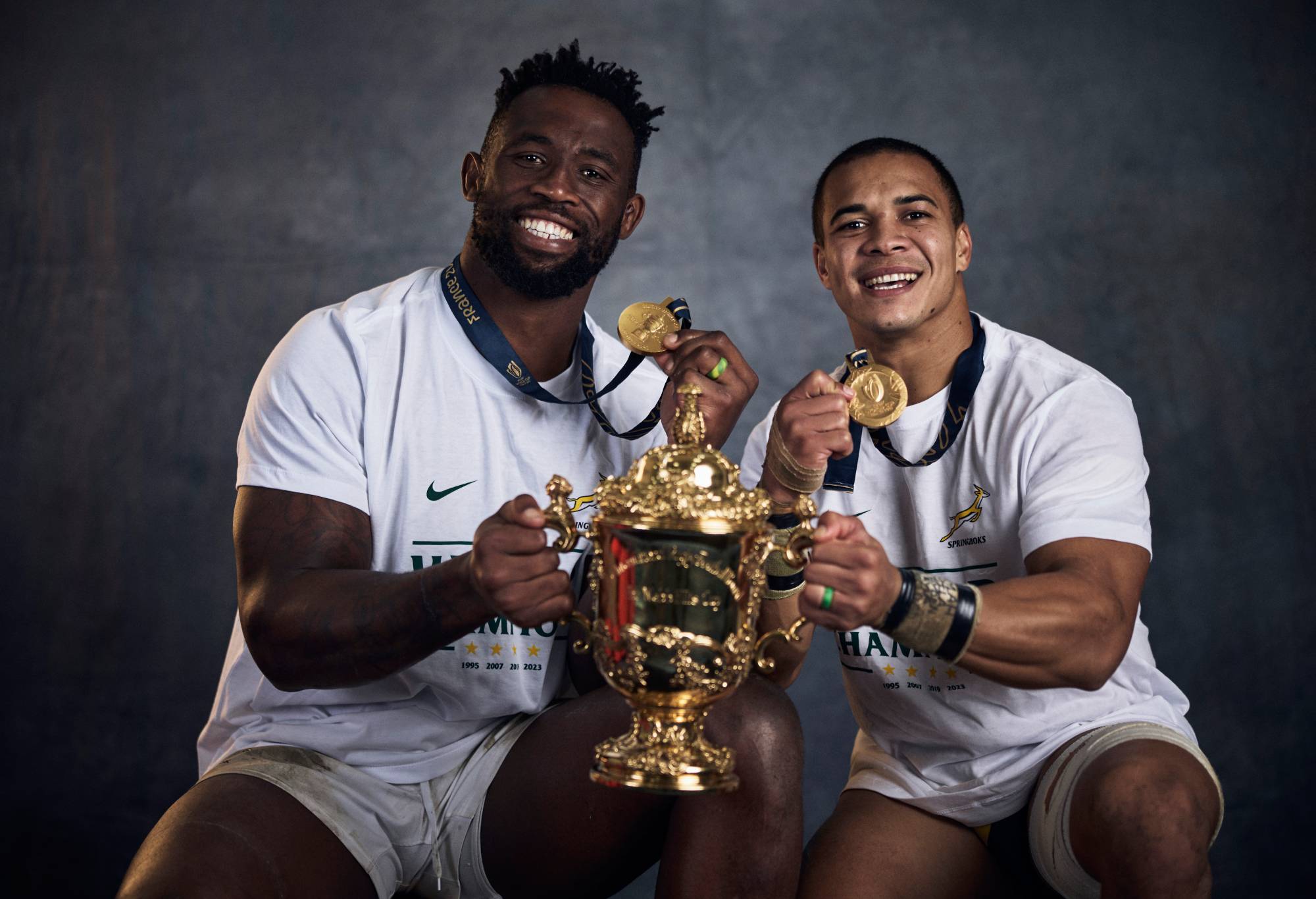 Siya Kolisi and Cheslin Kolbe of South Africa pose with the Webb Ellis Cup during the South Africa Winners Portrait shoot after the Rugby World Cup Final match between New Zealand and South Africa at Stade de France on October 29, 2023 in Paris, France. (Photo by Adam Pretty - World Rugby/World Rugby via Getty Images)