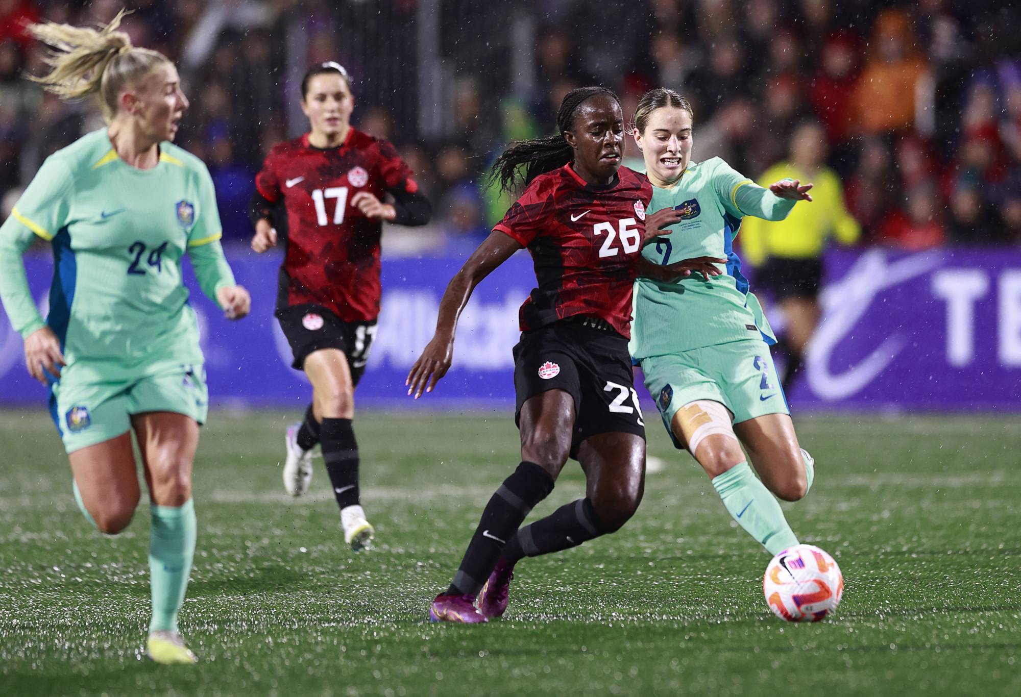 Simi Awujo #26 of Canada and Courtney Nevin #2 of Australia battle for the ball during the first half of their friendly match at Starlight Stadium on December 01, 2023 in Langford, British Columbia. (Photo by Jeff Vinnick/Getty Images for Football Australia)