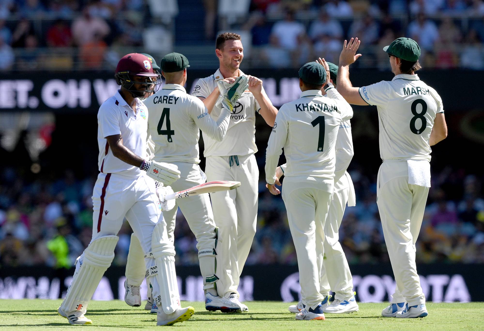 BRISBANE, AUSTRALIA - JANUARY 25: Josh Hazlewood of Australia celebrates with team mates after taking the wicket of Kraigg Brathwaite of the West Indies during day one of the Second Test match in the series between Australia and West Indies at The Gabba on January 25, 2024 in Brisbane, Australia.