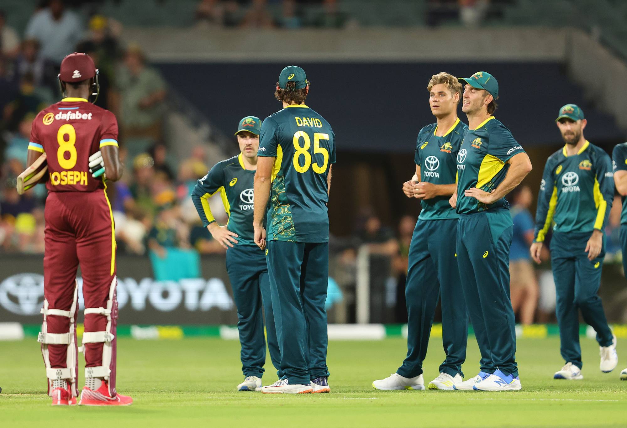 ADELAIDE, AUSTRALIA - FEBRUARY 11: Mitchell Marsh of Australia stands with his team as the umpire gets clarification on the run out of Alzarri Joseph of the West Indies by Spencer Johnson of Australia. Since no one in Australian team appealed it was ruled Not Out during game two of the mens T20 International series between Australia and West Indies at Adelaide Oval on February 11, 2024 in Adelaide, Australia. (Photo by Sarah Reed/Getty Images)