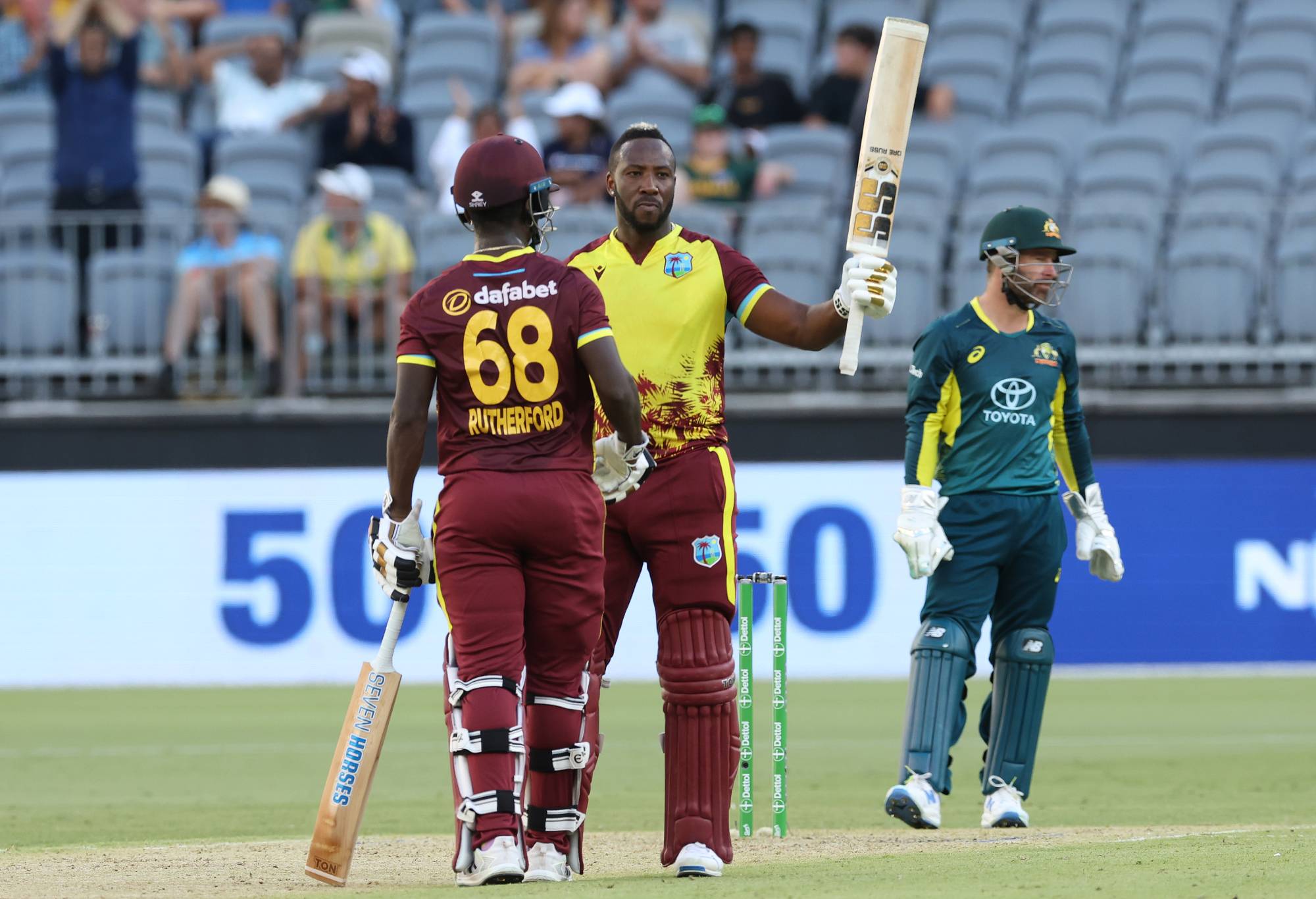 PERTH, AUSTRALIA - FEBRUARY 13: Andre Russell of the West Indies raises his bat after scoring fifty runs during game three of the Men's T20 International series between Australia and West Indies at Optus Stadium on February 13, 2024 in Perth, Australia. (Photo by Will Russell - CA/Cricket Australia via Getty Images)