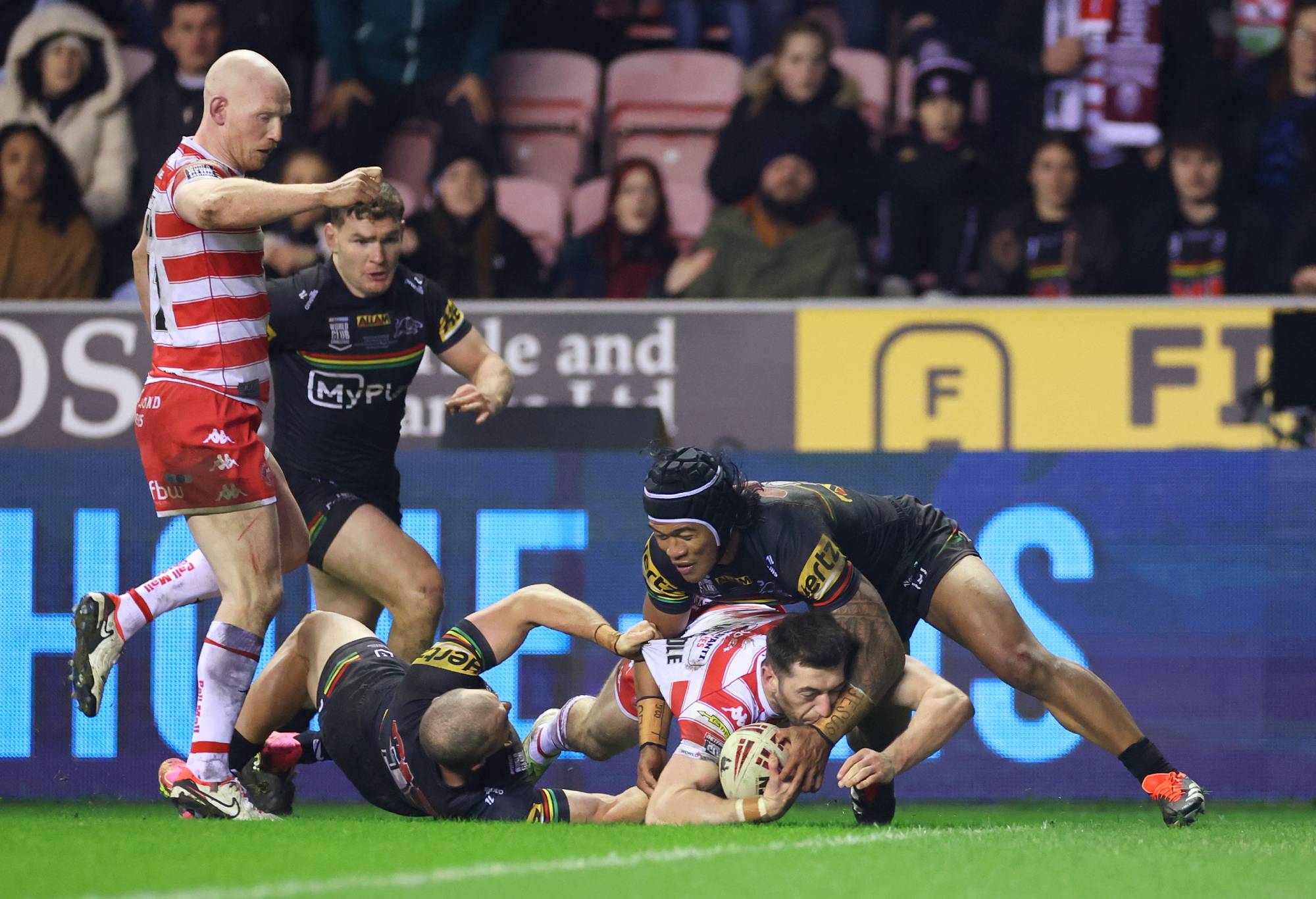 WIGAN, ENGLAND - FEBRUARY 24: Jake Wardle of Wigan Warriors goes down before going over to score his team's third try during the Betfred World Club Challenge match between Wigan Warriors and Penrith Panthers at DW Stadium on February 24, 2024 in Wigan, England. (Photo by Lewis Storey/Getty Images)