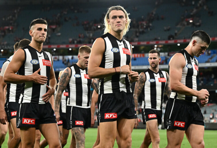 The Magpies look dejected after losing to the Swans