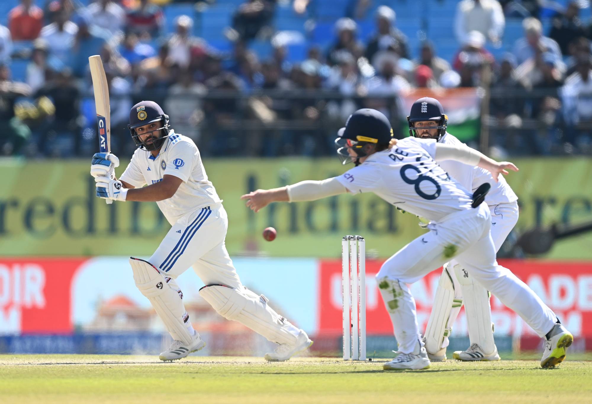 DHARAMSALA, INDIA - MARCH 08: India captain Rohit Sharma hits past England fielderOllie Pope during day two of the 5th Test Match between India and England at Himachal Pradesh Cricket Association Stadium on March 08, 2024 in Dharamsala, India. (Photo by Gareth Copley/Getty Images)
