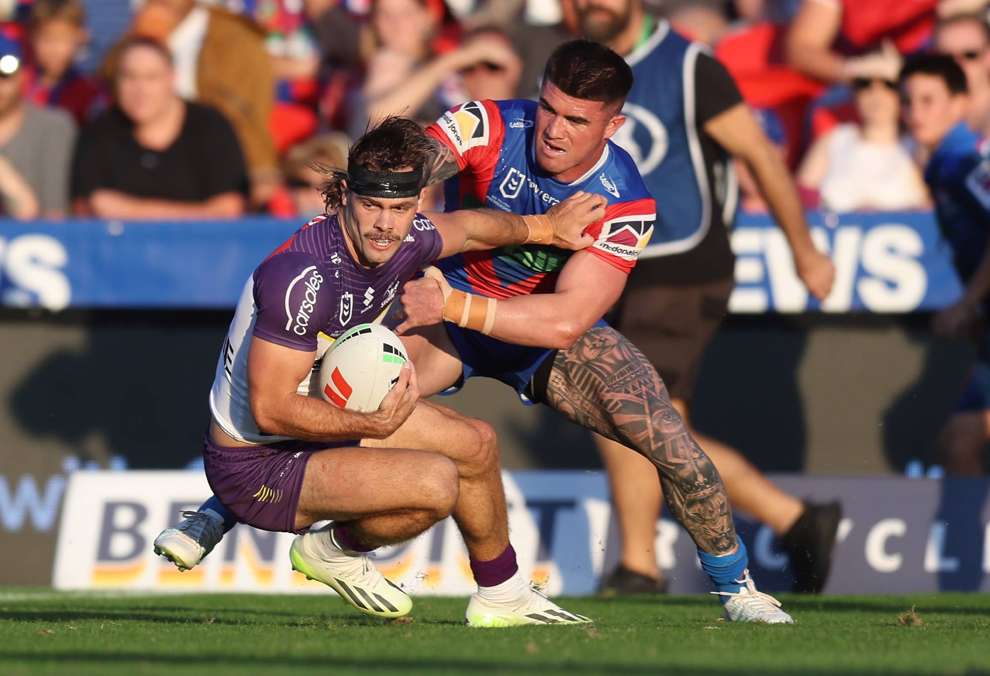 NEWCASTLE, AUSTRALIA - MARCH 24: Ryan Papenhuyzen of the Storm tackled by Bradman Best of the Knights during the round three NRL match between Newcastle Knights and Melbourne Storm at McDonald Jones Stadium, on March 24, 2024, in Newcastle, Australia. (Photo by Scott Gardiner/Getty Images)