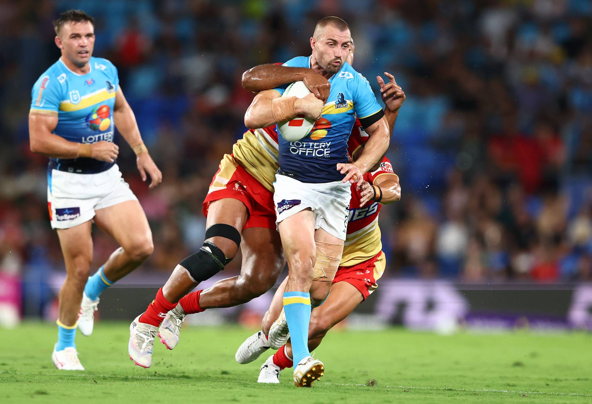 GOLD COAST, AUSTRALIA - MARCH 30: Kieran Foran of the Titans is tackled during the round four NRL match between Gold Coast Titans and Dolphins at Cbus Super Stadium, on March 30, 2024, in Gold Coast, Australia.