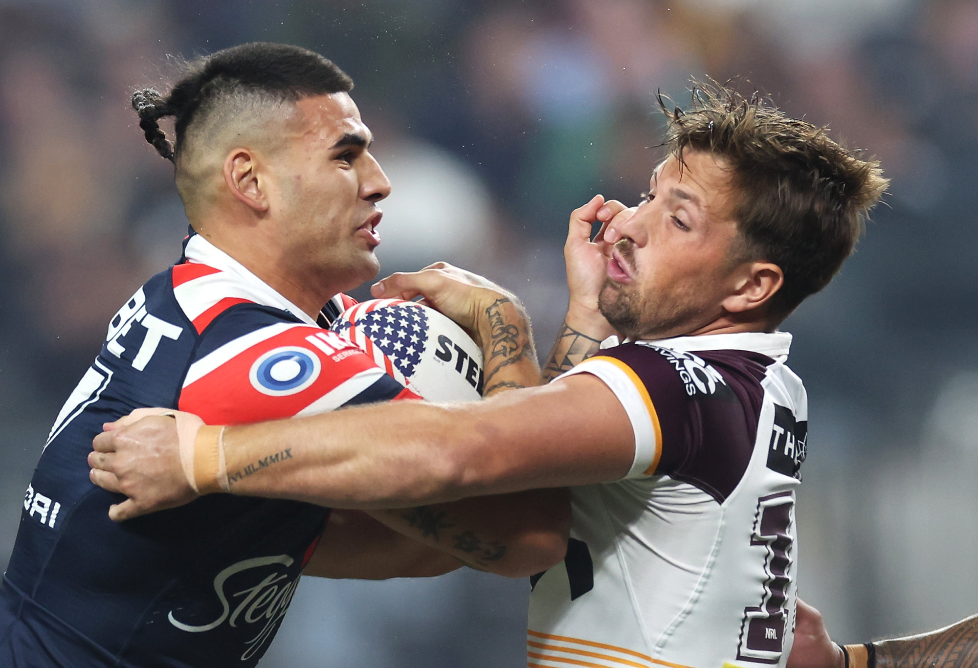 Terrell May of the Roosters is tackled by Tyson Smoothy of the Broncos