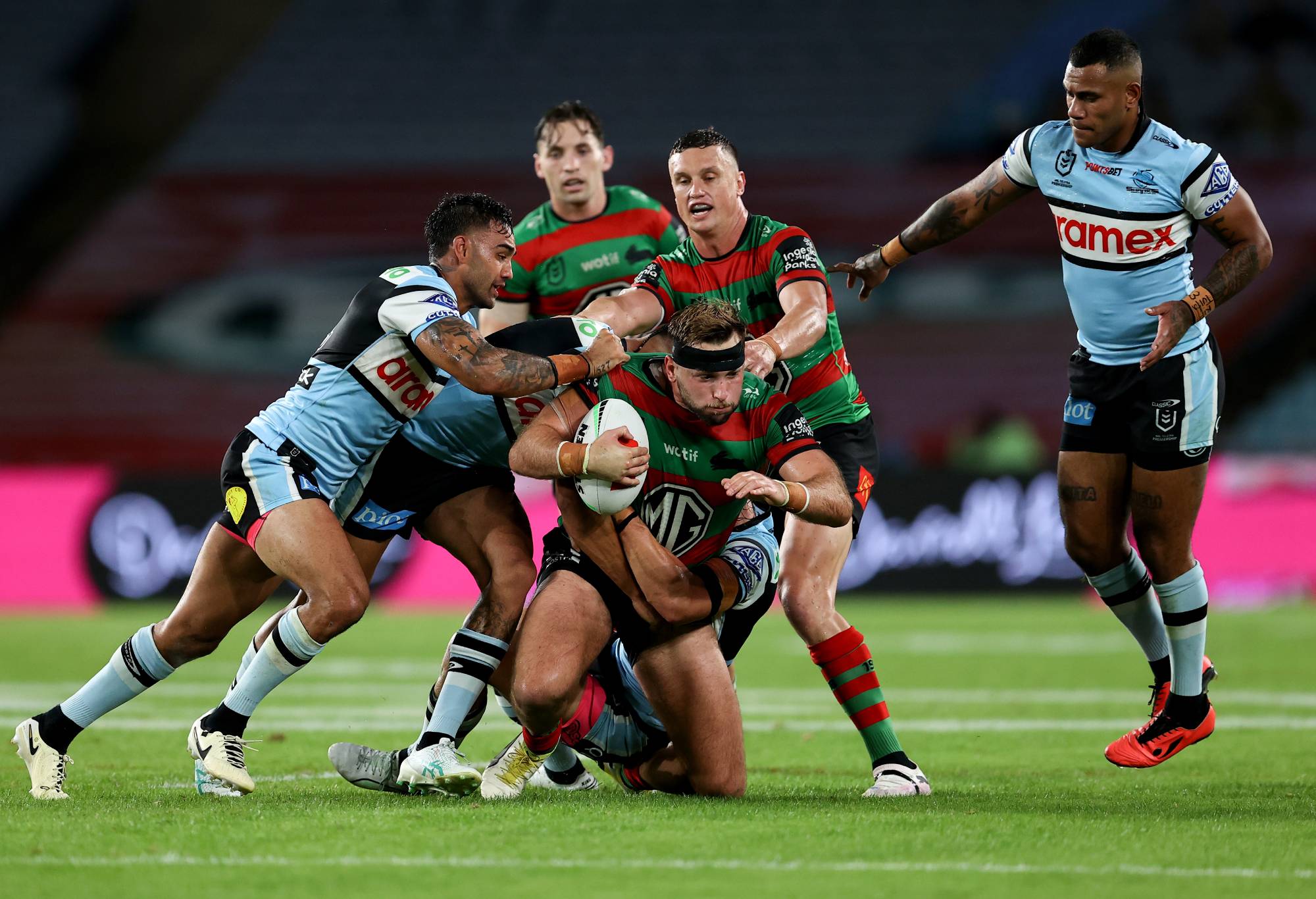 SYDNEY, AUSTRALIA - APRIL 13: Jacob Host of the Rabbitohs is tackled by the Sharks defence during the round six NRL match between South Sydney Rabbitohs and Cronulla Sharks at Accor Stadium, on April 13, 2024, in Sydney, Australia.